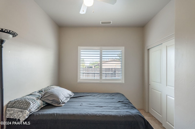 carpeted bedroom with ceiling fan and a closet