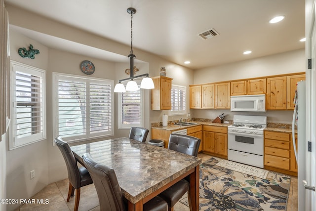 kitchen featuring sink, white appliances, hanging light fixtures, and light tile patterned floors