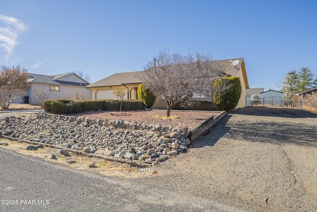 ranch-style house with a garage, driveway, and fence