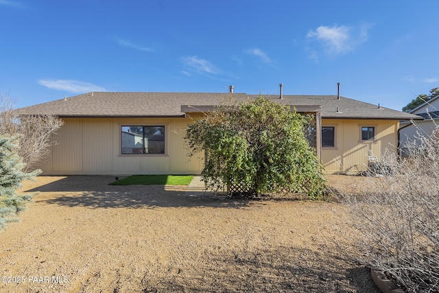 back of property featuring roof with shingles