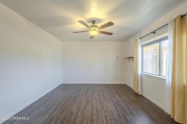 unfurnished room with dark wood-style flooring, ceiling fan, and baseboards