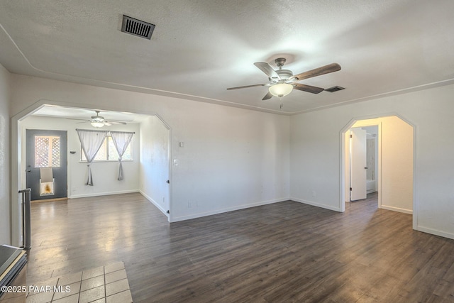 unfurnished room with arched walkways, ceiling fan, a textured ceiling, visible vents, and dark wood finished floors