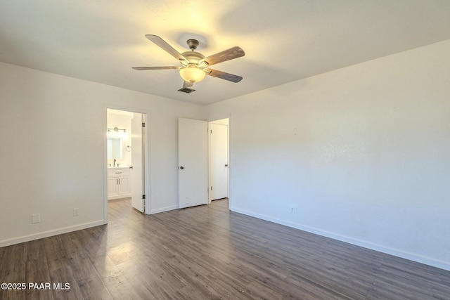 unfurnished bedroom with dark wood finished floors, visible vents, ensuite bathroom, a ceiling fan, and baseboards