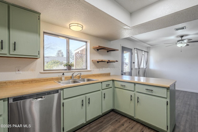 kitchen featuring green cabinetry, dishwasher, a peninsula, and a sink