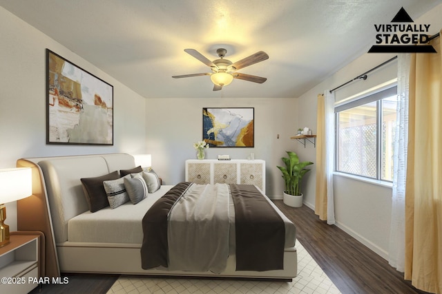 bedroom featuring dark wood-type flooring, a ceiling fan, and baseboards