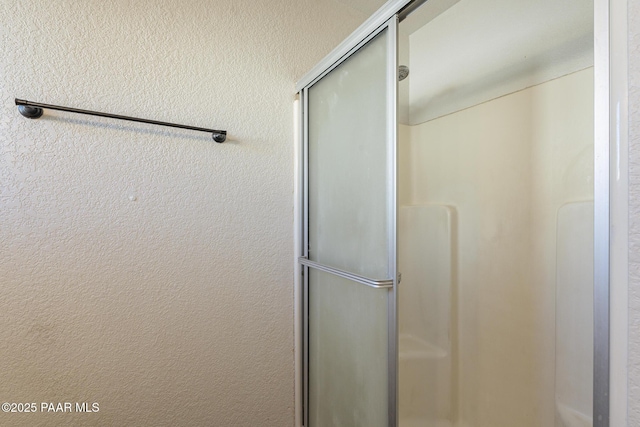 bathroom featuring a stall shower and a textured wall