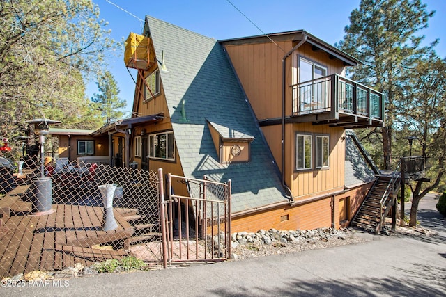 1520 W Sylvan Dr, Prescott, AZ 86305 - view of side of home featuring a balcony, a shingled roof, a gate, and stairway