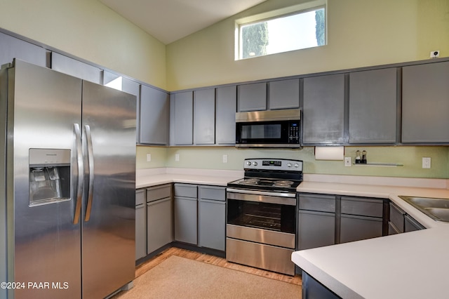 kitchen with gray cabinets, sink, light hardwood / wood-style floors, and appliances with stainless steel finishes