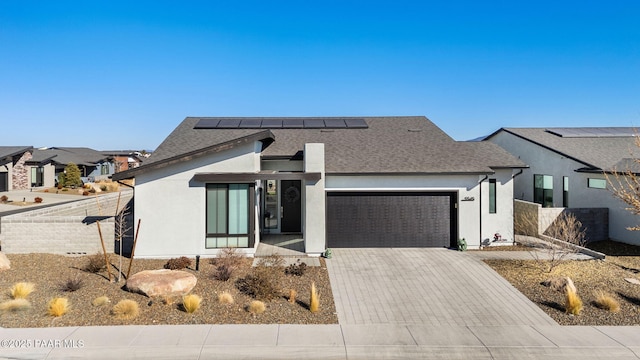 view of front facade with solar panels and a garage