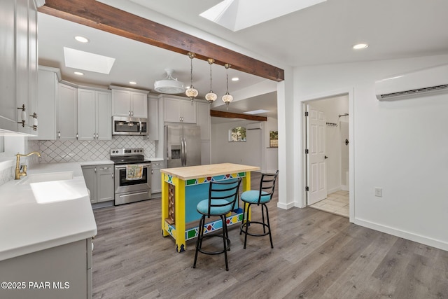 1467 N Vyne St, Prescott, AZ 86305 - kitchen with a wall mounted air conditioner, light wood-style flooring, stainless steel appliances, a sink, and backsplash