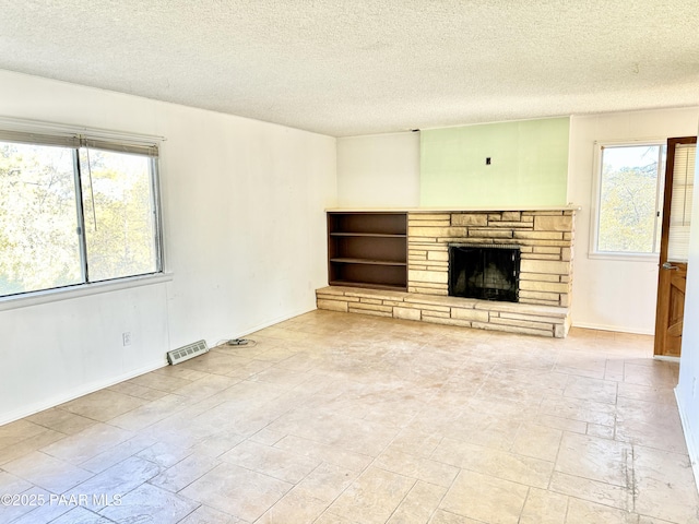 unfurnished living room featuring a fireplace and a textured ceiling