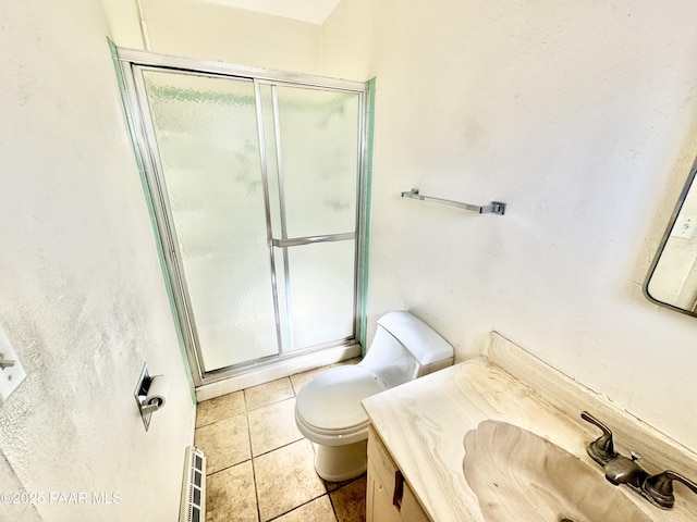 bathroom with tile patterned floors, vanity, toilet, and a shower with door