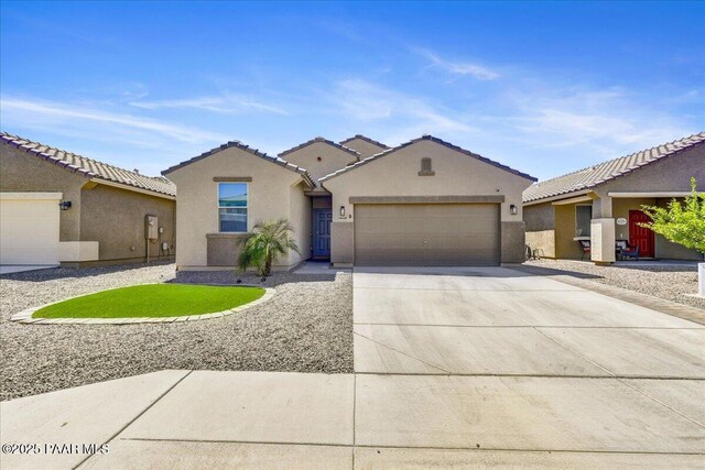 10429 W Crown King Rd, Tolleson, AZ 85353 - view of front of house with an attached garage, concrete driveway, stucco siding, and a tiled roof