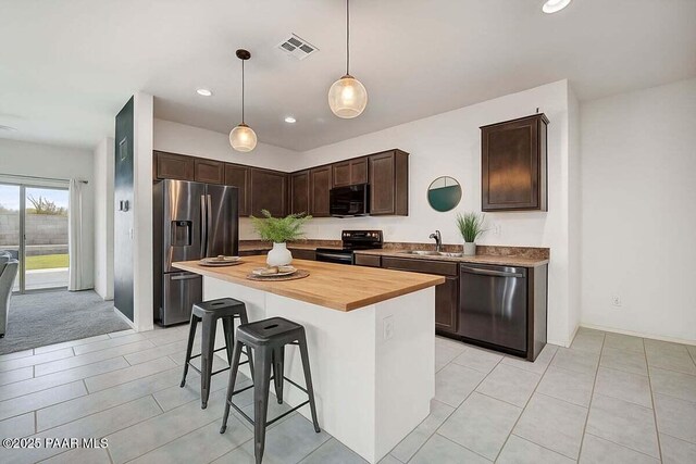 10429 W Crown King Rd, Tolleson, AZ 85353 - kitchen featuring appliances with stainless steel finishes, a sink, dark brown cabinets, a kitchen bar, and wooden counters