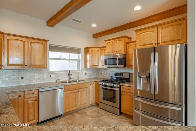 kitchen featuring beamed ceiling, light stone countertops, appliances with stainless steel finishes, sink, and backsplash