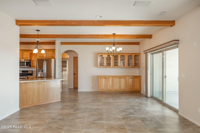 kitchen with decorative light fixtures, light stone countertops, appliances with stainless steel finishes, and a notable chandelier