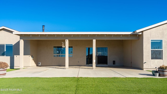 rear view of house with a patio area and a lawn