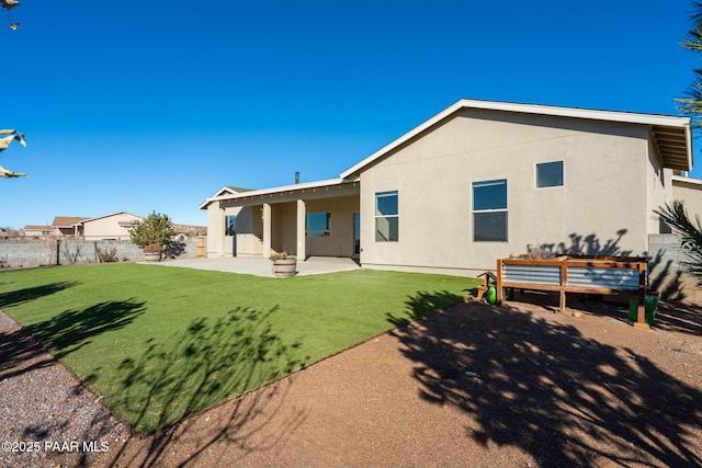 back of house with a yard and a patio