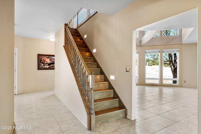 18900 N Butte Pass Rd, Prescott, AZ 86305 - stairs featuring tile patterned floors, baseboards, and a towering ceiling