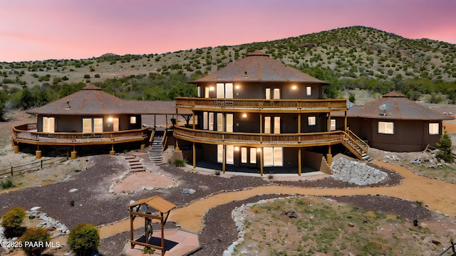 18900 N Butte Pass Rd, Prescott, AZ 86305 - back of property at dusk with stairway, a deck, and french doors