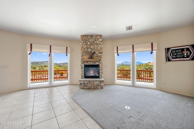 18900 N Butte Pass Rd, Prescott, AZ 86305 - unfurnished living room with plenty of natural light, a stone fireplace, tile patterned floors, and baseboards