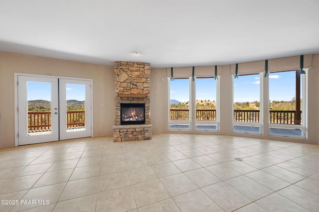 18900 N Butte Pass Rd, Prescott, AZ 86305 - unfurnished living room featuring tile patterned floors, a stone fireplace, french doors, and a mountain view