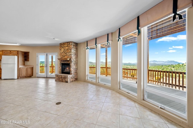 18900 N Butte Pass Rd, Prescott, AZ 86305 - unfurnished living room featuring light tile patterned floors, a fireplace, and a mountain view