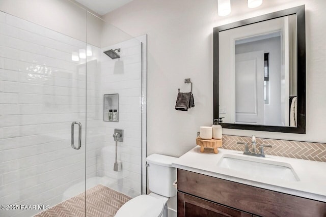 bathroom with an enclosed shower, vanity, and toilet