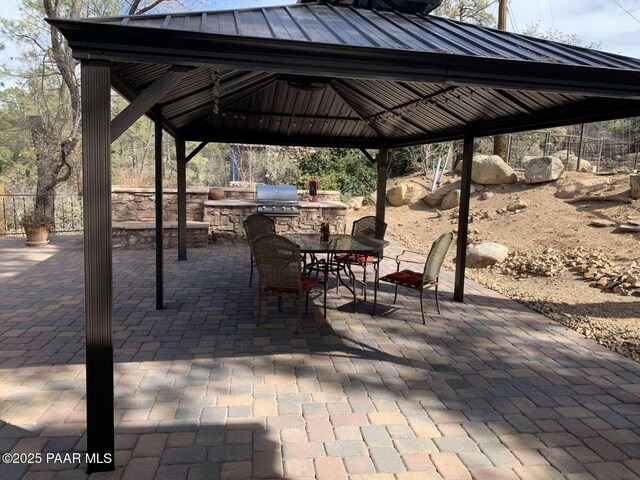 view of patio / terrace with fence, outdoor dining area, area for grilling, and a gazebo