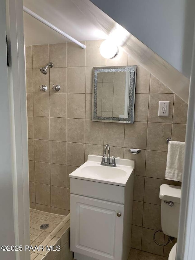 bathroom featuring vanity, a shower stall, toilet, and tile walls