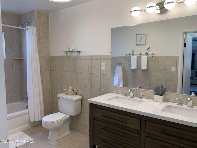 bathroom with shower / bath combination with curtain, tile walls, a sink, and tile patterned floors