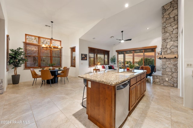 kitchen featuring ceiling fan with notable chandelier, sink, dishwasher, lofted ceiling, and an island with sink