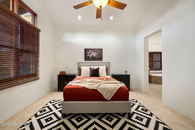 tiled bedroom featuring ensuite bath and ceiling fan