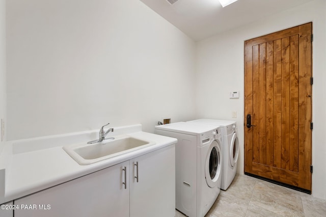 laundry area with washing machine and clothes dryer, sink, and cabinets