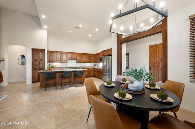 dining space featuring sink and a high ceiling