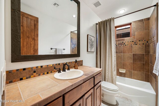 full bathroom featuring shower / bath combination with curtain, vanity, and toilet