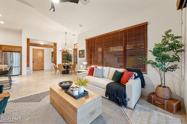 living room featuring high vaulted ceiling and a notable chandelier