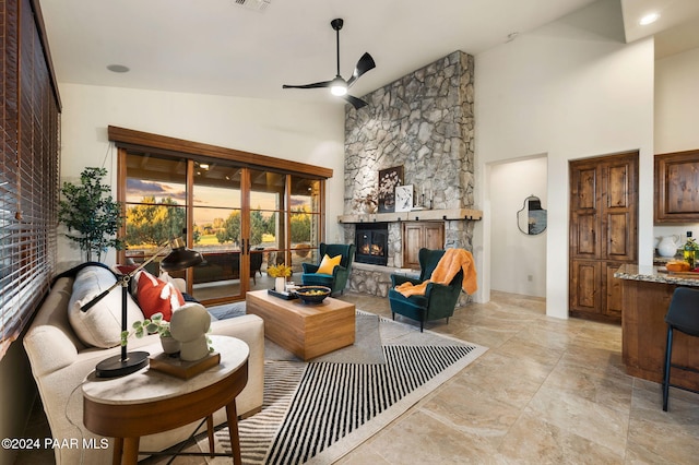 living room with high vaulted ceiling, a stone fireplace, and ceiling fan