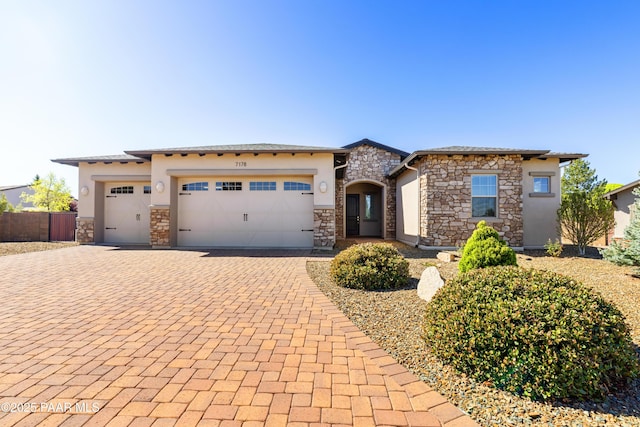 7178 N Lucky Shoe Cir, Prescott Valley, AZ 86315 - prairie-style house with a garage, decorative driveway, fence, stone siding, and stucco siding