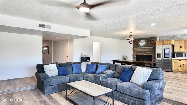 477 W State Route 260, Camp Verde, AZ 86322 - living area featuring visible vents, a textured ceiling, light wood finished floors, and a fireplace