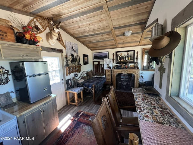 kitchen featuring dark hardwood / wood-style floors, lofted ceiling, stainless steel refrigerator, and wooden ceiling