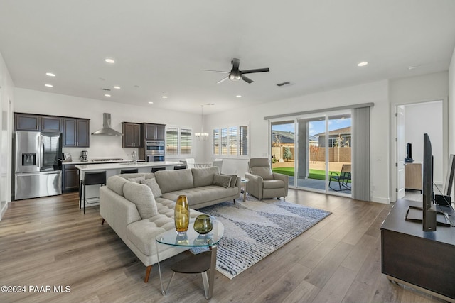 living room with ceiling fan, light hardwood / wood-style floors, sink, and a healthy amount of sunlight