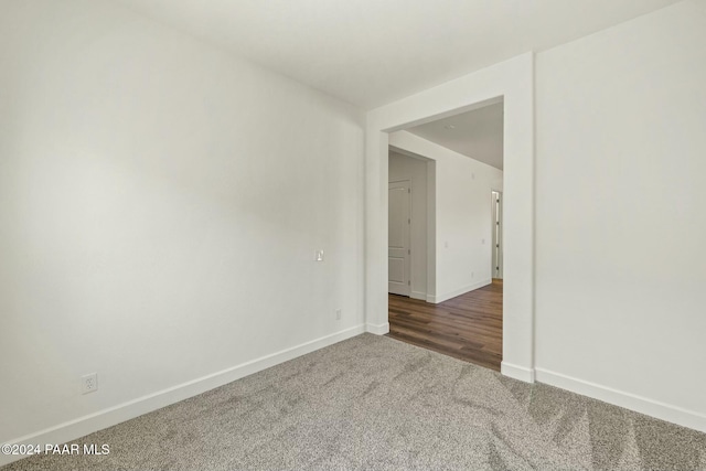 unfurnished room featuring dark carpet