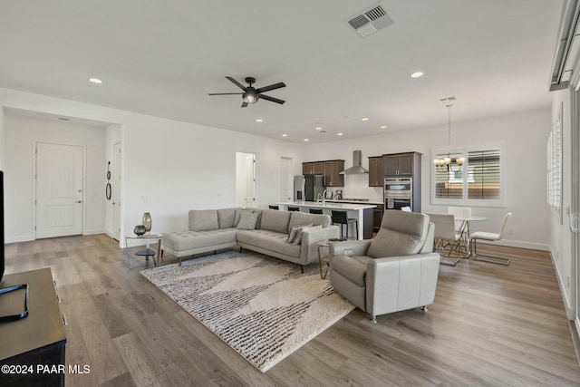 living room with ceiling fan and light hardwood / wood-style flooring