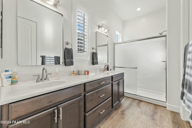 bathroom featuring vanity, hardwood / wood-style floors, and a shower with shower door