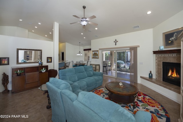 tiled living room featuring ceiling fan, a fireplace, and lofted ceiling