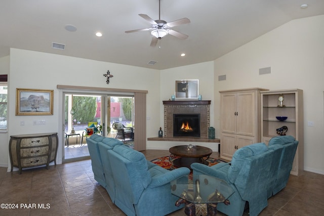 living room with ceiling fan, lofted ceiling, and a fireplace