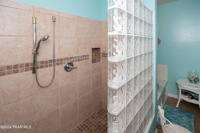 bathroom with a tile shower and tile patterned flooring