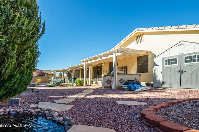 back of house with a pergola, a patio, and a storage unit