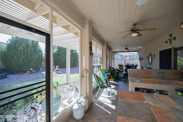 sunroom with ceiling fan and wood ceiling